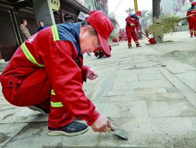 运城500余名环卫工人分组清理盬街施工留下各种垃圾